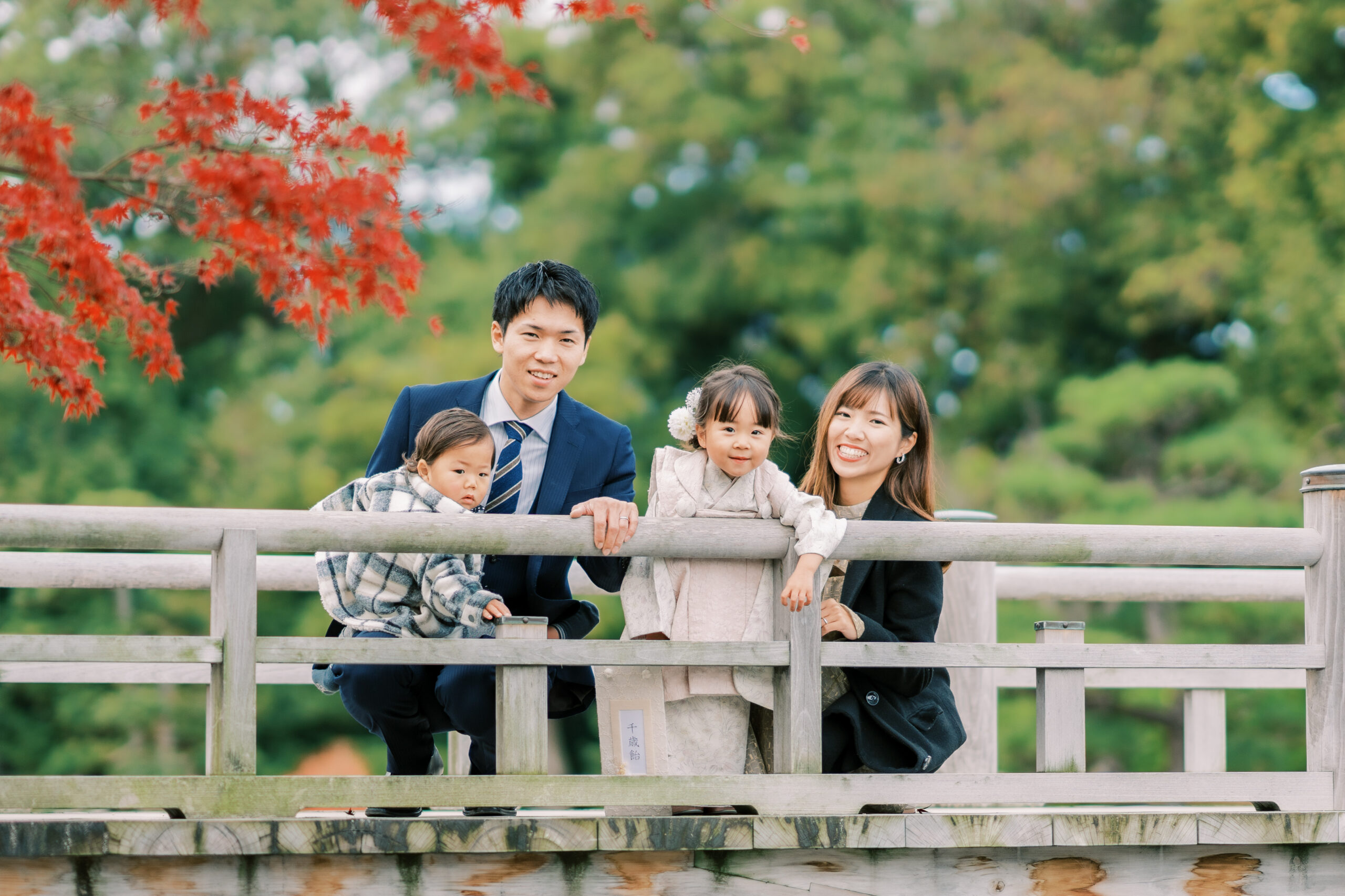 Family walking under maple canopy, candid travel moment in Japan